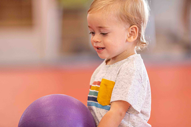 young boy with a purple ball
